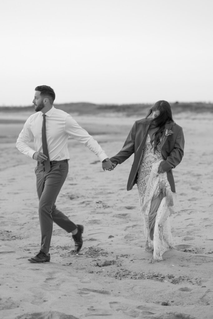 candid black and white elopement couple walking at the beach in Cape Cod