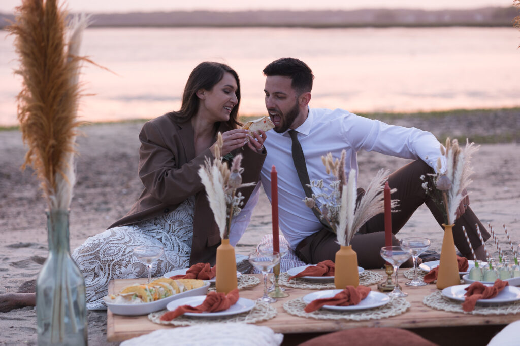 bride and groom enjoying an elopement picnic at the beach