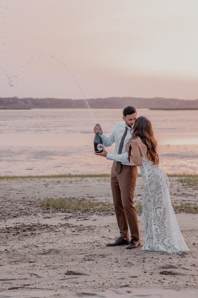 fun champagne pop at the end of a romantic Cape Cod beach elopement day