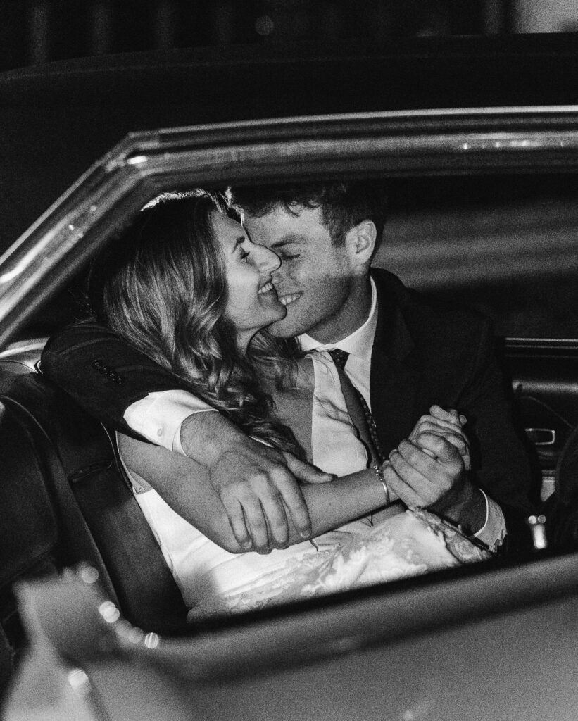 black and white photo of elopement couple in a classic car