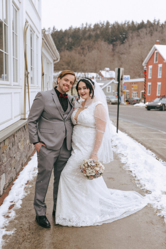 elopement couple wandering through snowy streets in Stowe