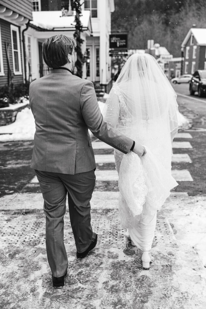 elopement couple wandering through snowy streets in Stowe