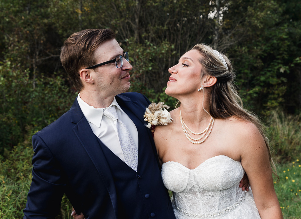 elopement couple kissing surrounded by lush forest in Maine