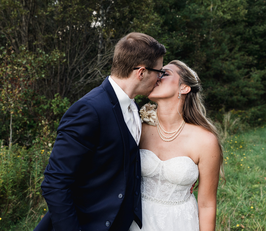 elopement couple kissing surrounded by lush forest in Maine