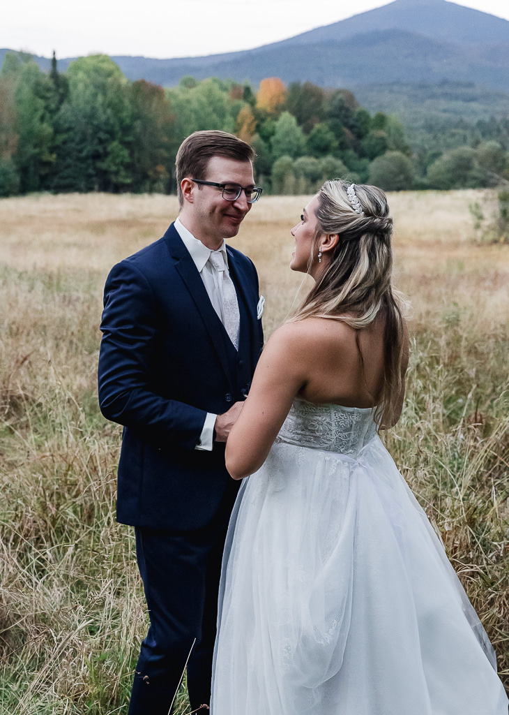 bride and groom in a field with  mountain backdrops during their berkshires elopement