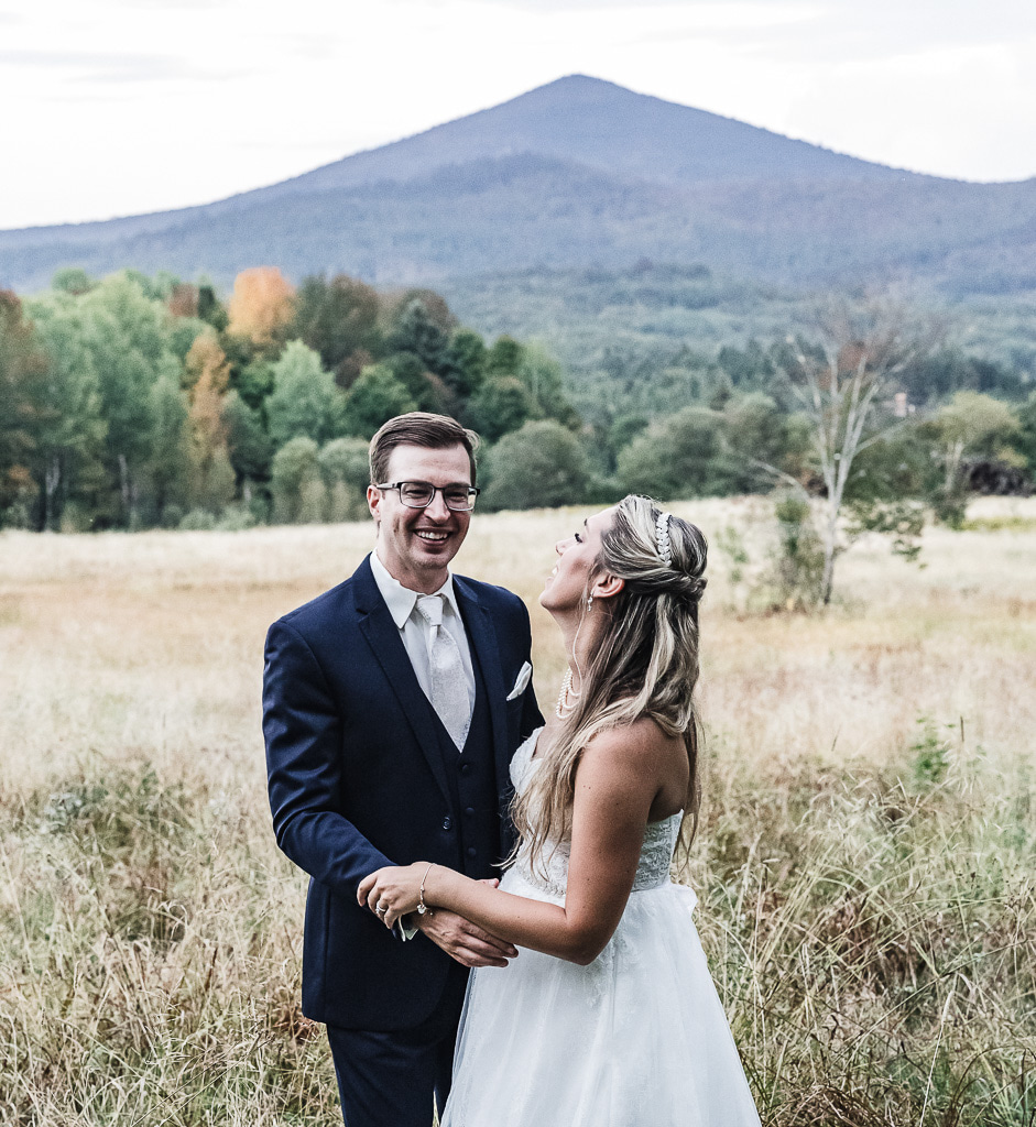 bride and groom in a field with  mountain backdrops during their berkshires elopement