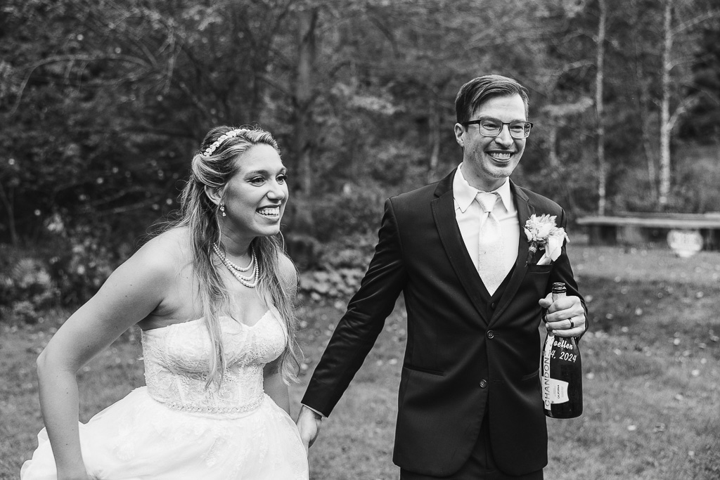 excited bride and groom about to sip champagne from the bottle