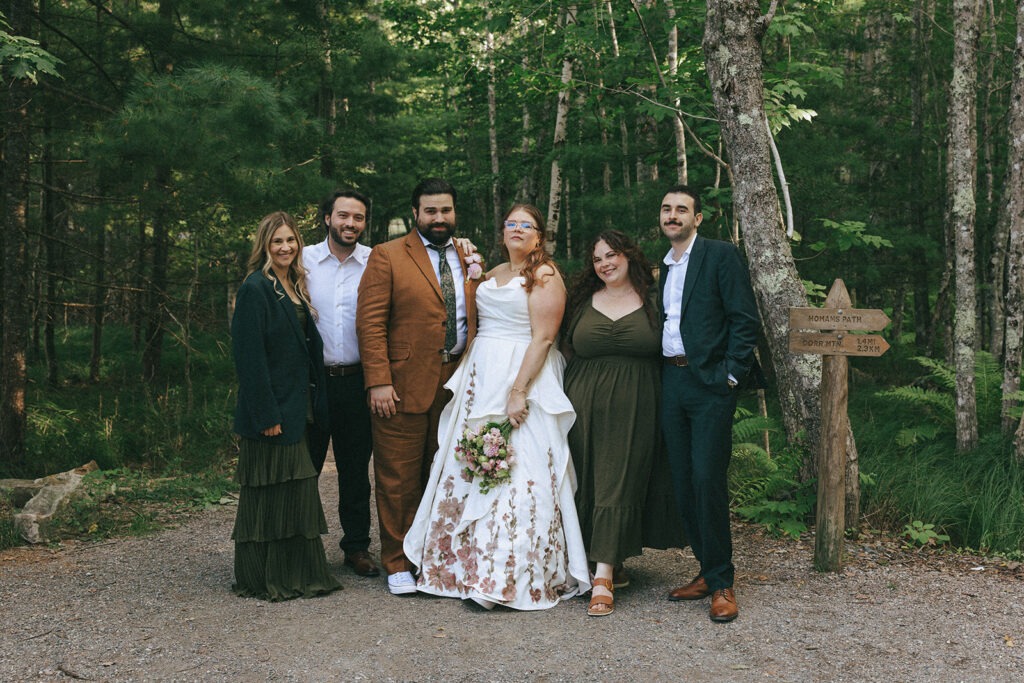 Couple posing with four wedding guests beside a trail in Acadia National Park